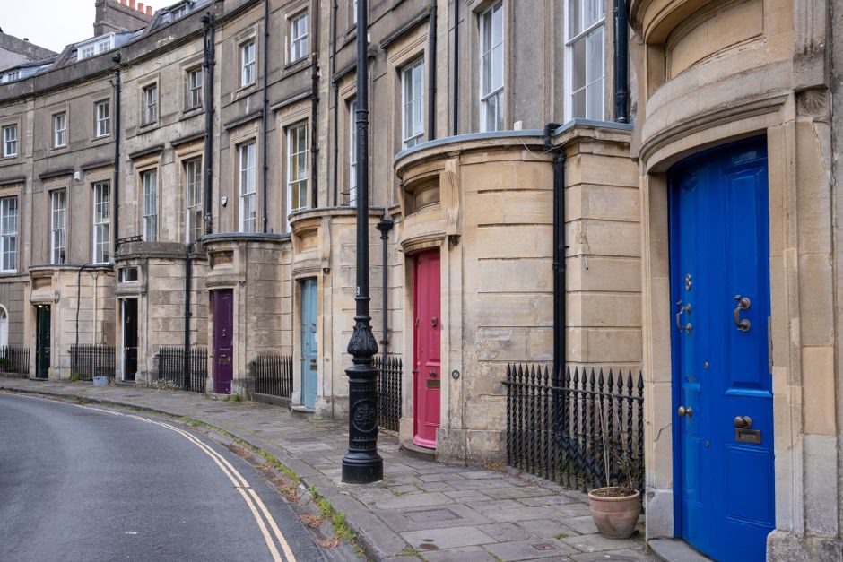 Elegant Georgian terrace houses with vibrant doors in Bath, showcasing architectural charm.