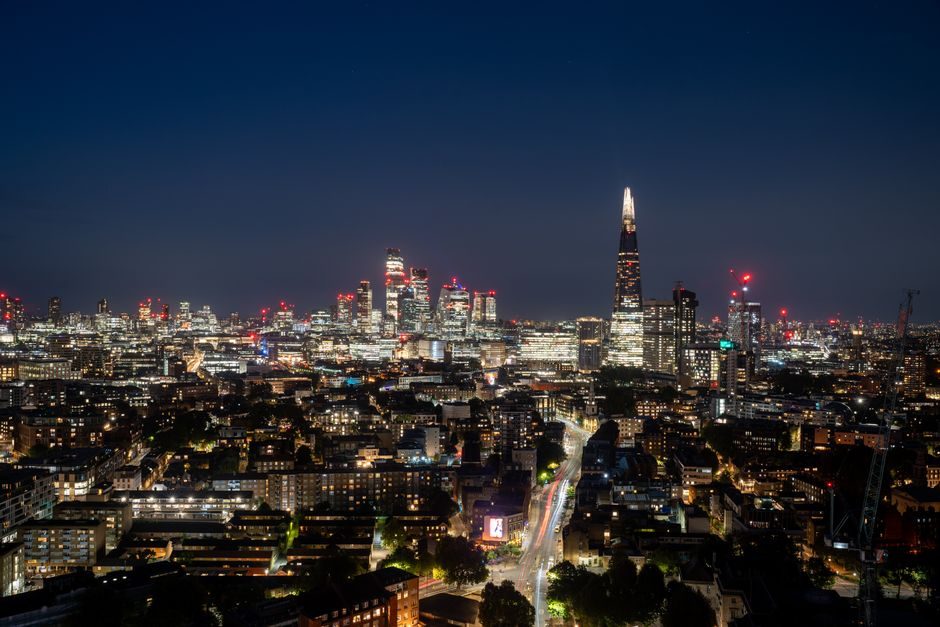 Capture a mesmerizing view of London's skyline featuring The Shard and skyscrapers illuminated at night.