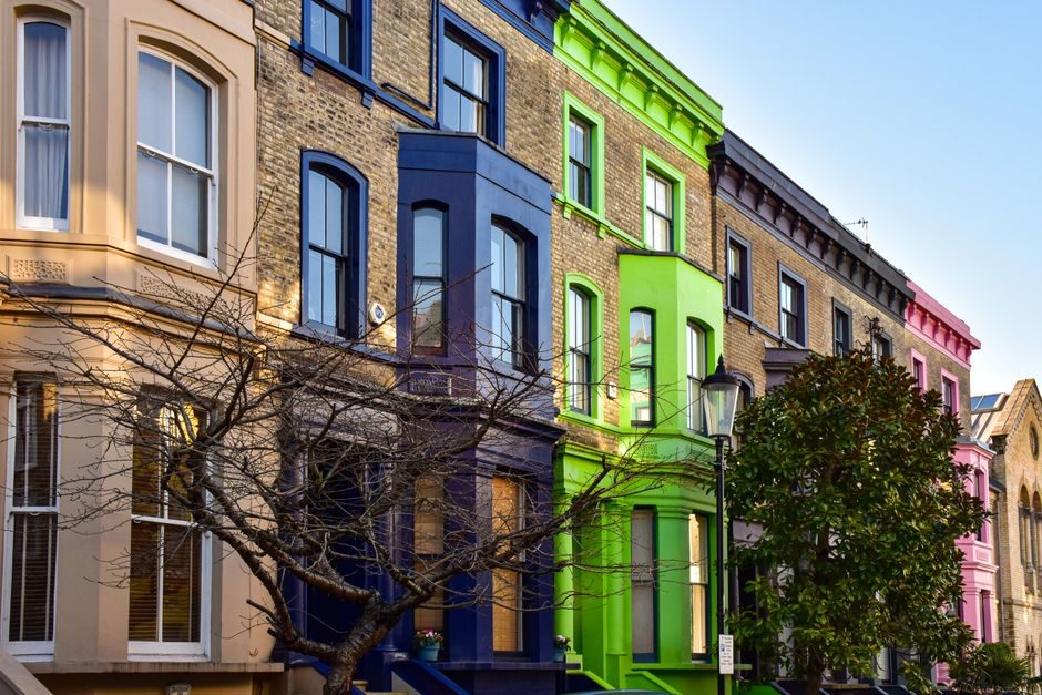 Vibrant row houses in lively London neighborhood, showcasing distinct architecture and colors.