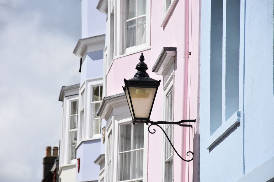 Pastel-colored building facades and vintage street lamp in Oxford, England.