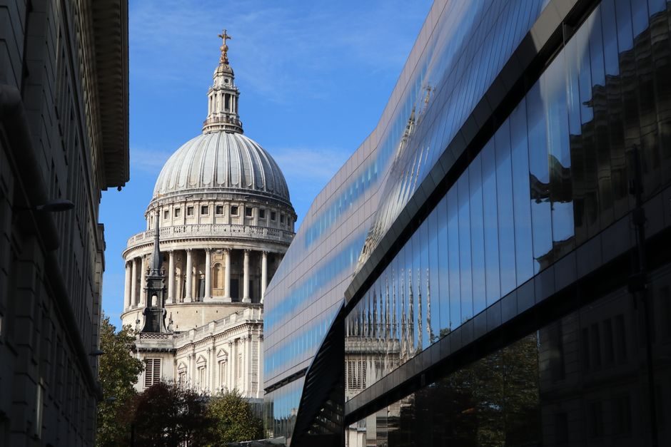 St. Paul's Cathedral dome seen alongside modern glass architecture in London.