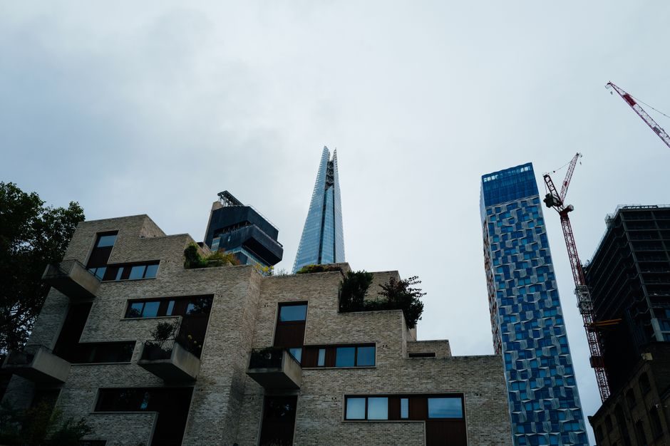 Dynamic cityscape featuring the Shard amidst modern architecture and construction cranes.