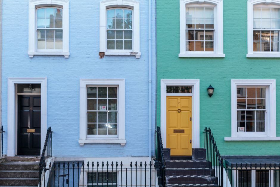 Charming colorful facades of urban row houses with distinct doors and windows.