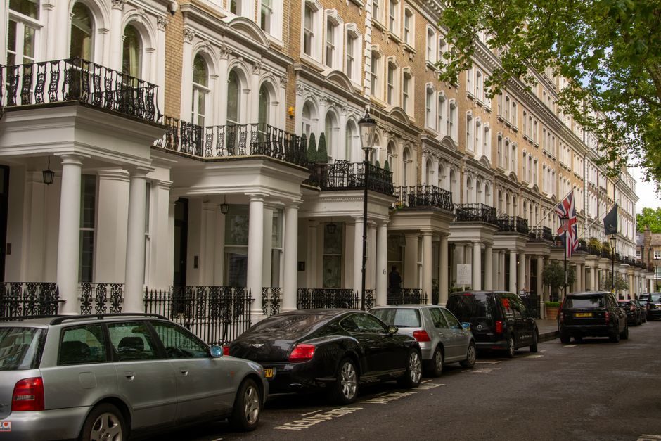 Row of luxury Georgian terrace houses with parked cars in London, United Kingdom.