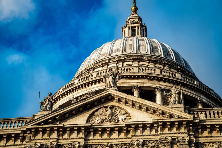 The majestic dome of St. Paul's Cathedral in London against a bright blue sky.