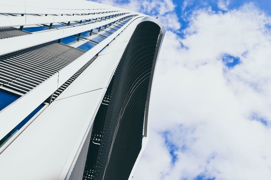 Modern architecture of a futuristic skyscraper captured against a blue sky in London.