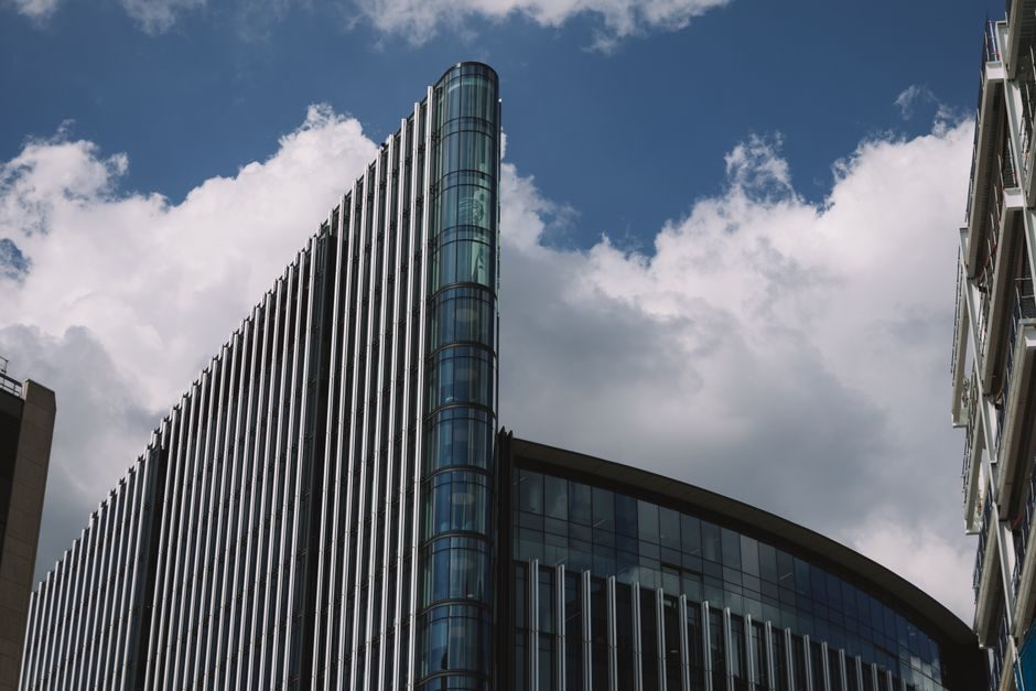 A striking modern skyscraper in London with dramatic clouds in the background.