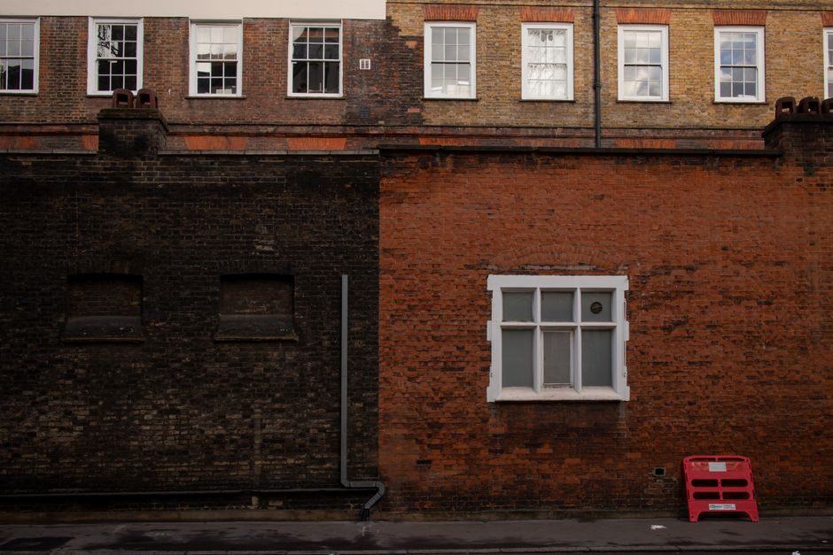 A detailed view of a classic brick wall in London with windows and architectural details.