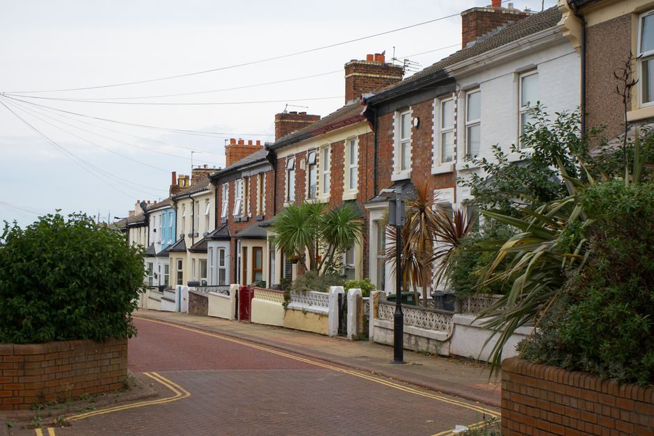 A row of freehold brick terraced houses on a leafy residential street in London