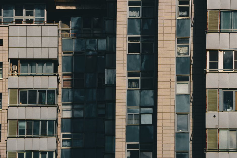Modern new-build apartment building with glass facade beside a London river