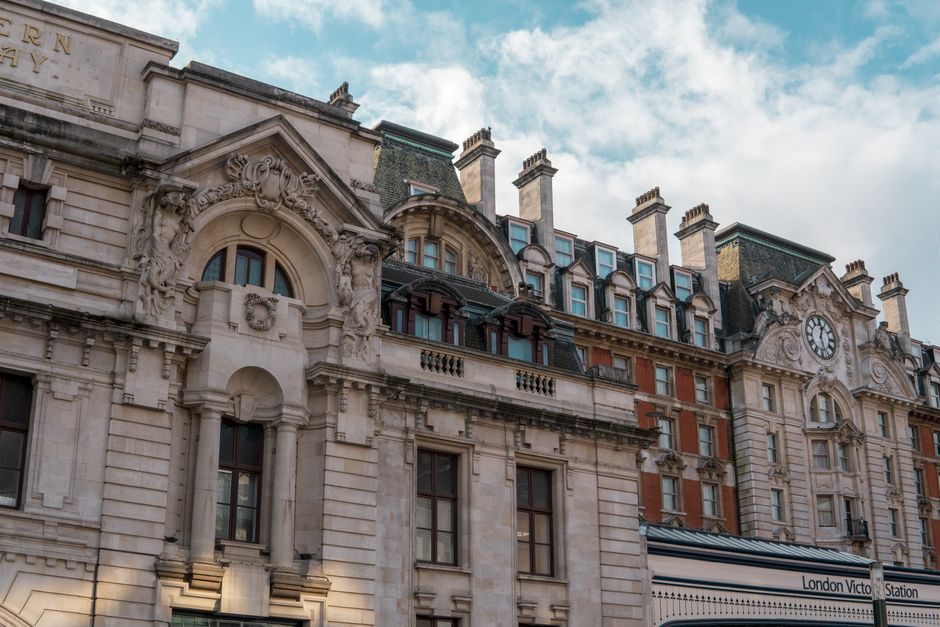Elegant facade of London Victoria Station capturing classic architectural beauty with daylight sky.