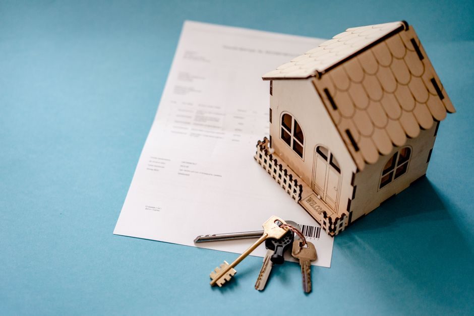 Signing UK mortgage paperwork with house keys on the table