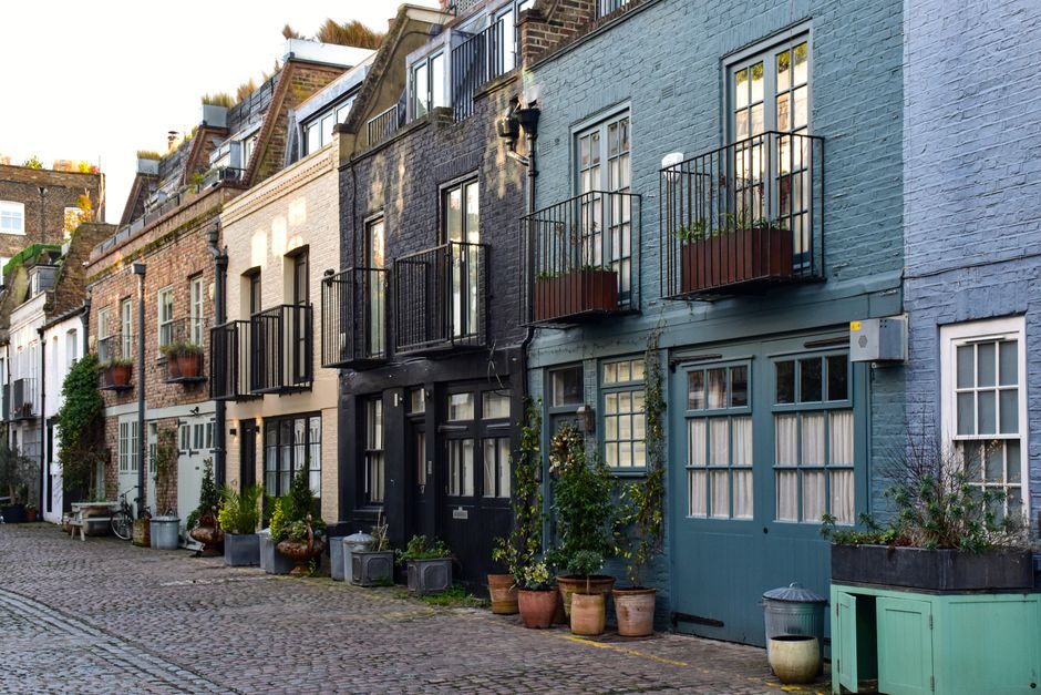 A quiet London residential street of Victorian brick terraced houses on a sunny afternoon