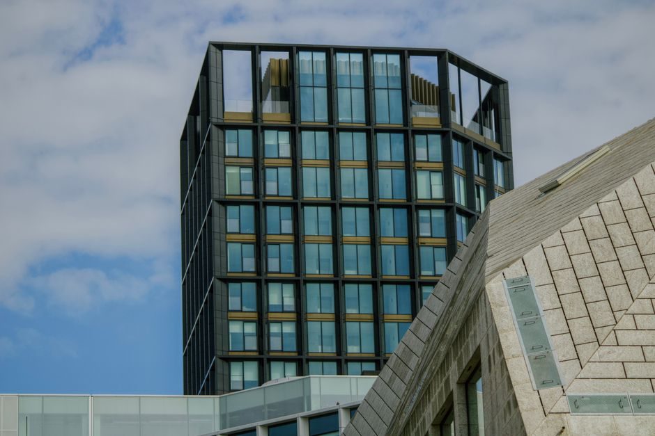 High-rise modern building facade contrasting with unique rooftop design in Dublin.