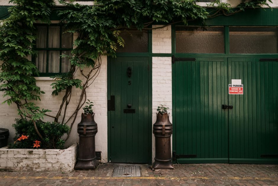Beautiful green doors with ivy in Notting Hill, London capture a quaint street charm.