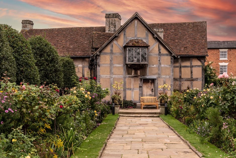A beautiful Tudor-style house surrounded by a lush garden in Stratford-upon-Avon.