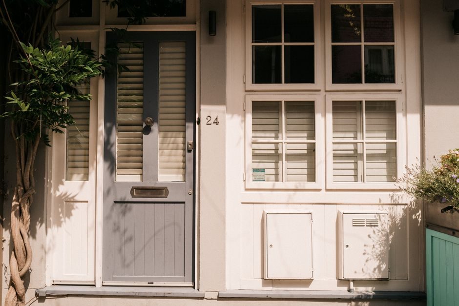 Close-up of a London home's facade featuring a charming white and grey door with shuttered windows.