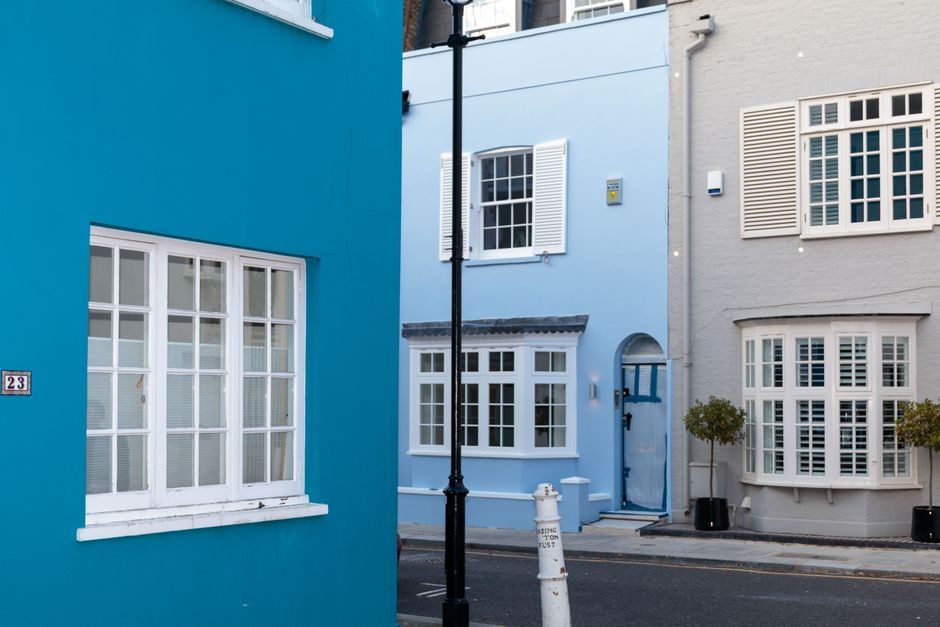 Exterior of district with colorful residential  houses with big windows with shutters at daytime